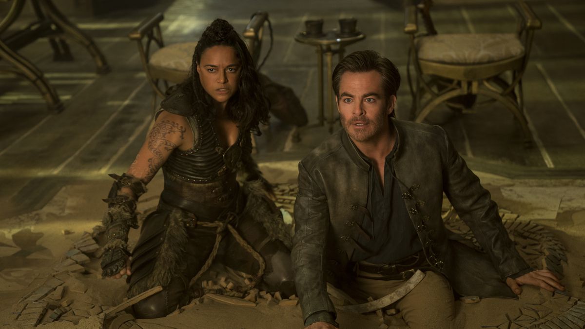 Michelle Rodriguez et Chris Pine ont l'air surpris alors qu'ils sont agenouillés sur le sol dans Dungeons &  Dragons : l'honneur parmi les voleurs.