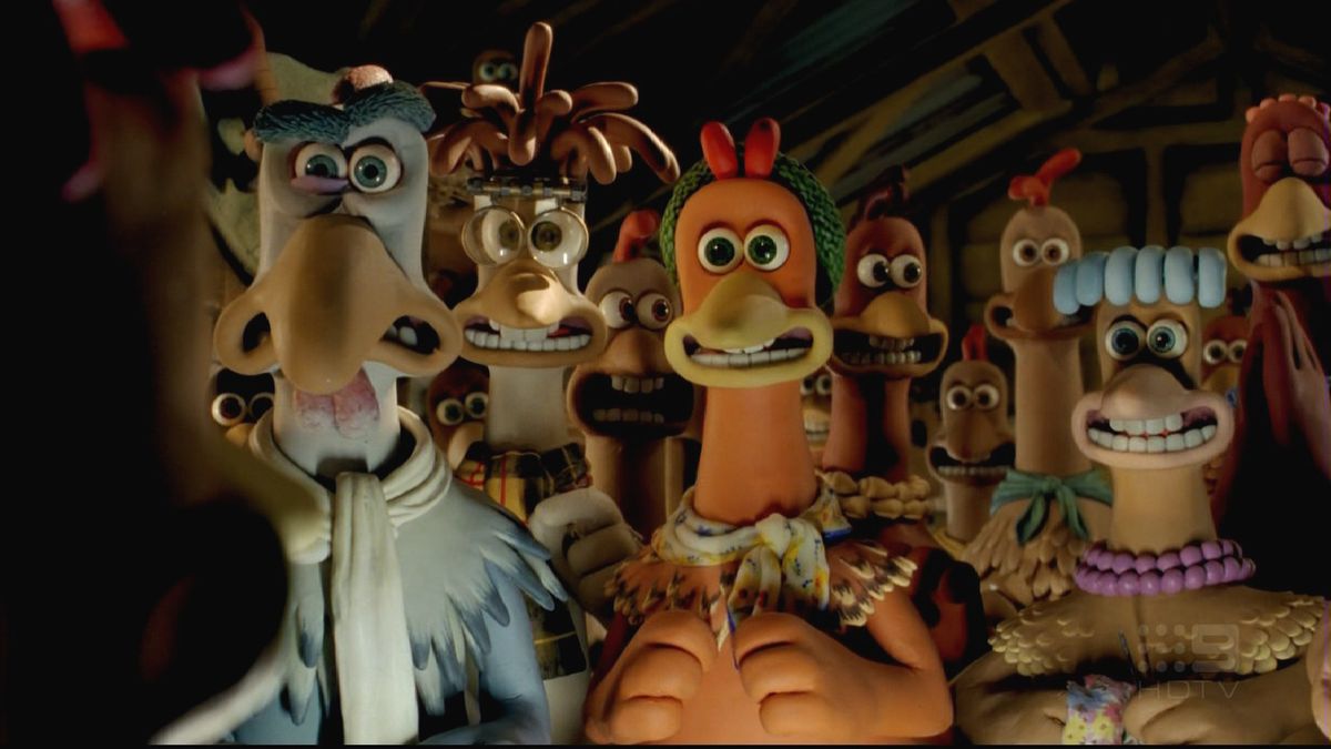 Un groupe de poulets regardant attentivement un coq dans Chicken Run.