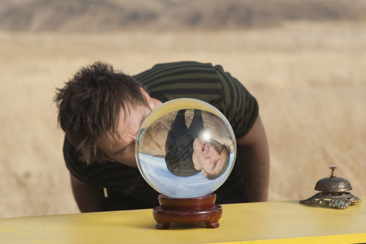 Dan Stevens regarde dans une boule de cristal, tandis qu'un autre Dan Stevens regarde sous un autre angle, dans Legion.