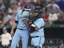 Le lanceur partant des Blue Jays de Toronto Kevin Gausman, à gauche, et le receveur Alejandro Kirk se concertent sur le monticule lors du troisième repas du match de baseball de l'équipe contre les Rangers du Texas à Arlington, Texas, le vendredi 16 juin 2023. Kirk a quitté le match de Toronto avec le Texas Rangers après avoir été touché par un lancer.