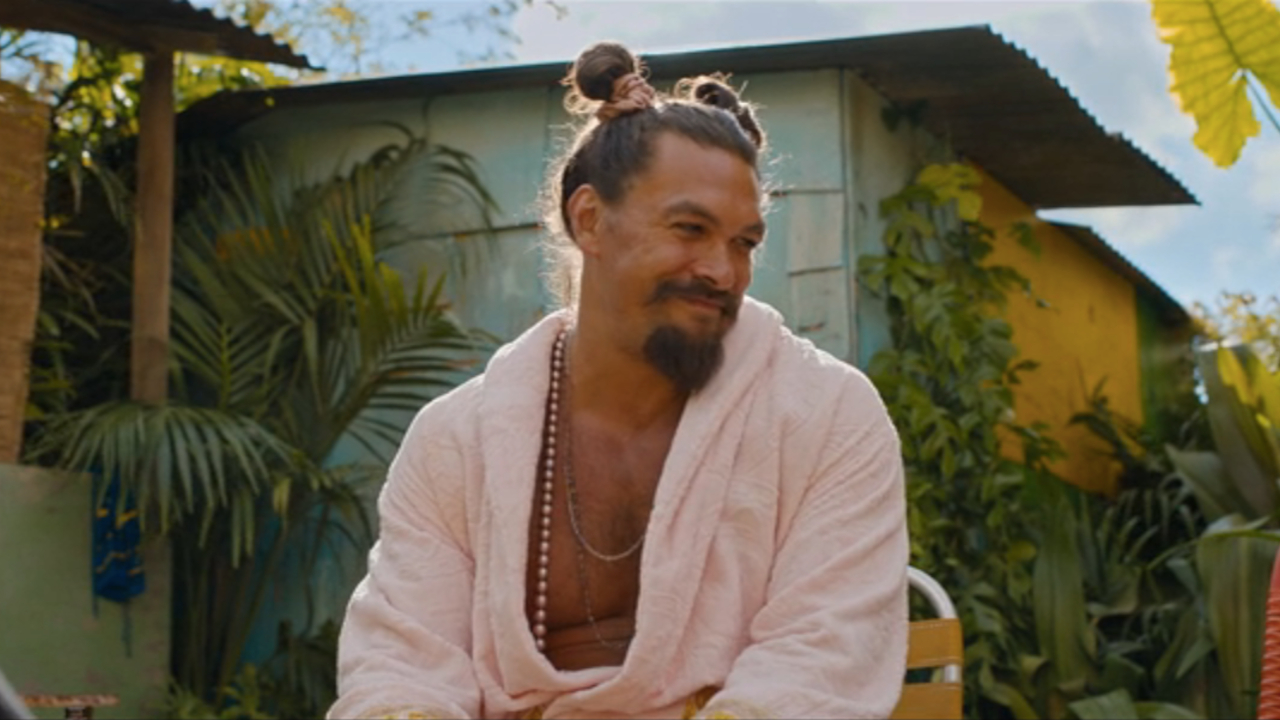 Jason Momoa sourit alors qu'il est assis dans un cadre ensoleillé dans Fast X.