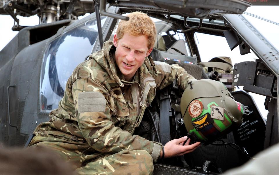 Le prince Harry, ou tout simplement le capitaine Wales, comme on l'appelle dans l'armée britannique, montre à une équipe de télévision son casque de vol alors qu'il effectue ses vérifications avant vol tôt le matin sur la ligne de vol, au Camp Bastion.