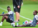 Sam Adekugbe, à gauche, et Richie Laryea se rendent mercredi sur le terrain du centre d'entraînement des Whitecaps de Vancouver pour leur première séance d'entraînement avec l'équipe. 