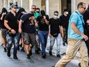 Des supporters de football, pour la plupart originaires de Croatie, se couvrent le visage en quittant le siège de la police d'Athènes à Athènes, alors qu'ils sont détenus dans le cadre de l'enquête sur la mort d'un supporter grec lors de violents affrontements le 9 août 2023. Plus d'un une centaine de personnes, dont 94 Croates, doivent comparaître devant le parquet d'Athènes, soupçonnées d'être impliquées dans la mort d'un supporter grec lors de violents affrontements le 7 août au soir entre des supporters du club de football croate Dinamo Zagreb et l'Aek d'Athènes en la banlieue de la capitale grecque.  