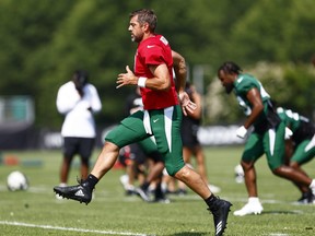 Le quart-arrière Aaron Rodgers des Jets de New York court pendant le camp d'entraînement.