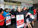 Lana Payne, présidente nationale d'Unifor, crie aux côtés des travailleurs sur une ligne de piquetage devant une épicerie Metro à Toronto.