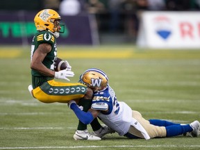 Demerio Houston (35 ans) des Blue Bombers de Winnipeg s'attaque à Dillon Mitchell (17 ans) des Elks d'Edmonton lors de la première demi-action de la LCF à Edmonton, en Alberta, le jeudi 10 août 2023. LA PRESSE CANADIENNE/Jason Franson.