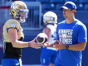 Les quarts Dru Brown (à gauche) et Zach Collaros échangent un ballon lors de l'entraînement des Blue Bombers de Winnipeg le lundi 14 août 2023.