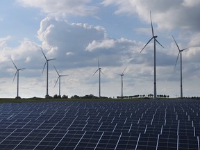 Éoliennes derrière un parc d'énergie solaire.