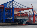 Un porte-conteneurs est amarré sous des grues navire-terre au port de Hambourg à Hambourg, en Allemagne.  La croissance économique est ce qui a sorti les gens de l'extrême pauvreté et permis des progrès dans les domaines de la santé, de l'éducation et de l'action personnelle, écrit Joe Oliver.