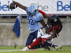 Le receveur éloigné des Argonauts DaVaris Daniels (à gauche) atteint la zone des buts pour un touché alors que le demi défensif des Rouge et Noir Abdul Kanneh défend à Toronto hier soir.