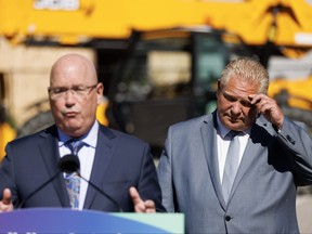 Le premier ministre de l'Ontario, Doug Ford, écoute le ministre du Logement, Steve Clark, lors d'une conférence de presse à Mississauga, le vendredi 11 août 2023.