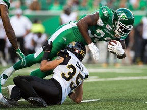 L'ancien porteur de ballon #33 des Roughriders de la Saskatchewan, Jerome Messam, est vu ici dans cette photo d'archive du 5 juillet 2018 abattue par Mike Daly, #35 des Tiger-Cats de Hamilton, lors d'un match de la LCF au Mosaic Stadium.  Il a été libéré par l'équipe le même mois après avoir été accusé de voyeurisme en Alberta.  Il fait maintenant face à une accusation similaire en Saskatchewan.