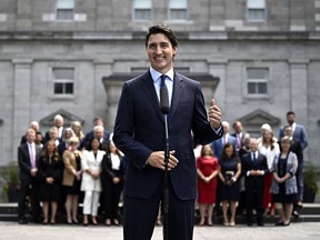 Le premier ministre Justin Trudeau s'apprête à livrer une nouvelle mission à son cabinet lors d'une retraite de trois jours à Charlottetown cette semaine dans le but de restaurer un sentiment de sécurité économique pour les Canadiens et une plus grande confiance des Canadiens dans son gouvernement. Trudeau fait un geste vers le cabinet fédéral alors qu'ils se tiennent derrière lui lors d'un point de presse après un remaniement ministériel, à Rideau Hall à Ottawa, le mercredi 26 juillet 2023.