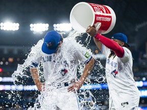 Jordan Romano des Blue Jays de Toronto est aspergé d'eau par son coéquipier Vladimir Guerrero Jr.