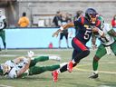 Le quart-arrière des Alouettes de Montréal Caleb Evans (5) s'éloigne de la défense des Roughriders de la Saskatchewan lors de la première mi-temps de l'action de football de la LCF à Montréal, le vendredi 11 août 2023.