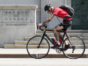 Un cycliste passe devant la Banque du Canada à Ottawa.