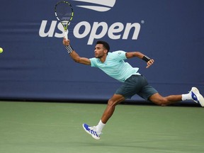 Félix Auger-Aliassime, du Canada, renvoie un tir à Mackenzie McDonald, des États-Unis, lors du premier tour des championnats de tennis de l'US Open, le lundi 28 août 2023, à New York.