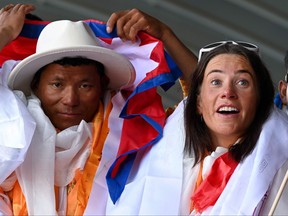 L'alpiniste norvégienne Kristin Harila (à droite) et le guide népalais Tenjin Sherpa font un geste à leur arrivée à l'aéroport international de Tribhuvan à Katmandou le 5 août 2023, après avoir établi le record du sommet le plus rapide des 14 8 000 mètres du monde (26 000 -pieds) montagnes.