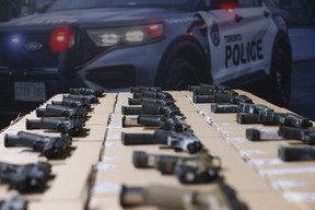 La police de Toronto présente 28 armes de poing saisies.  Un homme d'Ottawa a été arrêté et accusé de 135 accusations liées aux armes à feu et d'une accusation de non-respect d'une ordonnance de mise en liberté.  JACK BOLAND/SOLEIL DE TORONTO