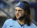 L'arrêt-court des Blue Jays de Toronto, Bo Bichette, marche dans l'abri avant un match de baseball contre les Dodgers de Los Angeles, à Los Angeles, le mardi 25 juillet 2023.