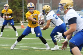 Le quart-arrière Zach Collaros (à gauche) passe la main à Brady Oliveira