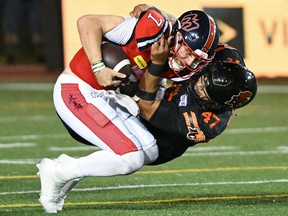 Le quart-arrière des Alouettes Cody Fajardo (7) est limogé par Sione Teuhema (47) des Lions de la Colombie-Britannique lors de la deuxième mi-temps d'un match de football de la LCF à Montréal, le samedi 2 septembre 2023.