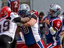 Le plaqueur offensif des Alouettes Josh Bourke bloque Charleston Hughes des Stampeders tout en protégeant le quart Anthony Calvillo lors d'un match en 2009. Les Alouettes remporteront la Coupe Grey cette année-là.  