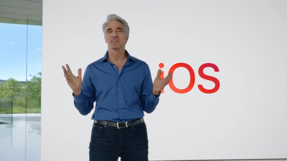 Craig Federighi, vice-président d'Apple, lors de l'événement d'ouverture de la WWDC.  Il se tient à l'intérieur d'Apple Park, devant un immense tableau blanc qui indique 