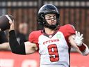 Le quart-arrière des Redblacks d'Ottawa Nick Arbuckle lance une passe lors de la première mi-temps d'un match de football de la LCF contre les Alouettes de Montréal en juin.