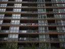 Un drapeau canadien sur le balcon d'un condo à Toronto.  La ville souffre de pénuries de soins de santé et de prix des logements inabordables.