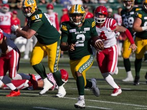 Le quart-arrière des Elks, Tre Ford, court avec le ballon, tandis qu'un défenseur des Stampeders de Calgary le poursuit.