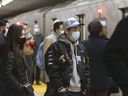 Des navetteurs montent à bord d'un train de la TTC à la gare Yonge-Bloor à Toronto le 20 mars 2022. 