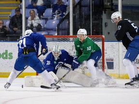 Le gardien des Canucks de Vancouver Thatcher Demko (35 ans) arrête Nils Hoglander (21 ans) alors que Teddy Blueger (53 ans) défend et que Tyler Myers (57 ans) et Elias Pettersson (40 ans) regardent la journée d'ouverture du camp d'entraînement de l'équipe de hockey de la LNH, à Victoria, jeudi. , 21 septembre 2023.