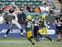 Le receveur des Lions de la Colombie-Britannique, Justin McInnis, réussit un touché contre Marloshawn Franklin Jr. (32) et Kai Gray (29) des Elks d'Edmonton au cours de la première moitié de leur rencontre du 29 juillet à Edmonton. 