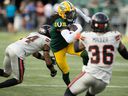 Steven Dunbar Jr. (7) des Elks d'Edmonton affronte Marcus Sayles (14) et Quincy Mauger (36) des Lions de la Colombie-Britannique lors de la première moitié de l'action de la LCF au Stade du Commonwealth, à Edmonton, le 29 juillet 2023. 