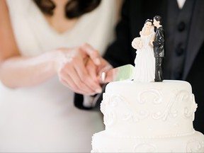 Un couple nouvellement marié coupe son gâteau de mariage.