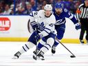 Le défenseur des Maple Leafs Jake McCabe (à gauche) et Nicholas Paul du Lightning de Tampa Bay se battent pour la rondelle lors du quatrième match du premier tour des séries éliminatoires de la Coupe Stanley 2023 à l'Amalie Arena, le 24 avril 2023 à Tampa. 