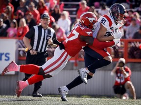 Le receveur des Alouettes Austin Mack, à droite, est plaqué par le secondeur des Stampeders Micah Awe à Calgary, le samedi 23 septembre 2023.