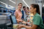 Femme heureuse payant ses courses à la caisse.