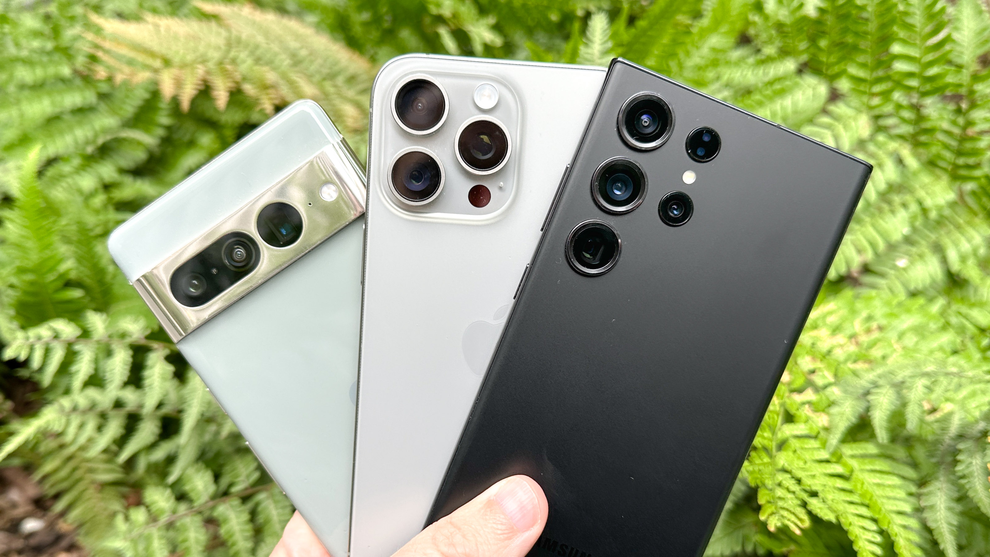 Appareil photo Google Pixel 7 Pro, iPhone 15 Pro Max et Galaxy S23 Ultra présenté tenu dans une main