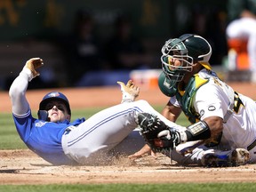 Cavan Biggio des Blue Jays marque en glissant devant le receveur Carlos Perez de l'Athlétisme en début de deuxième manche au RingCentral Coliseum le mercredi 6 septembre 2023 à Oakland.