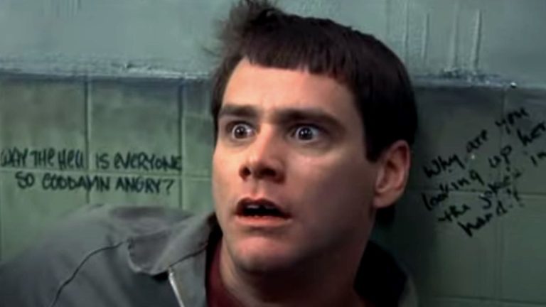 Jim Carrey backed against a bathroom wall with a look of horror in Dumb and Dumber.