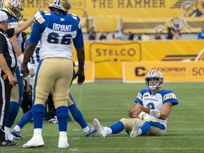 Le quart-arrière des Blue Bombers de Winnipeg, Zach Collaros, est assis sur le terrain après avoir été limogé samedi par les Tiger Cats de Hamilton.