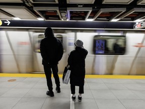 Des gens attendent sur le quai pour monter dans une rame de métro au centre-ville de Toronto.