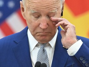 Le président américain Joe Biden fait des gestes tandis que le secrétaire général du Parti communiste vietnamien, Nguyen Phu Trong, s'adresse aux médias au siège du Parti communiste vietnamien à Hanoï, le 10 septembre 2023.