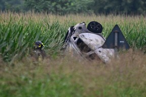 Un pompier se tient près des restes d'une voiture heurtée par un avion de l'équipe nationale de voltige aérienne Frecce Tricolori