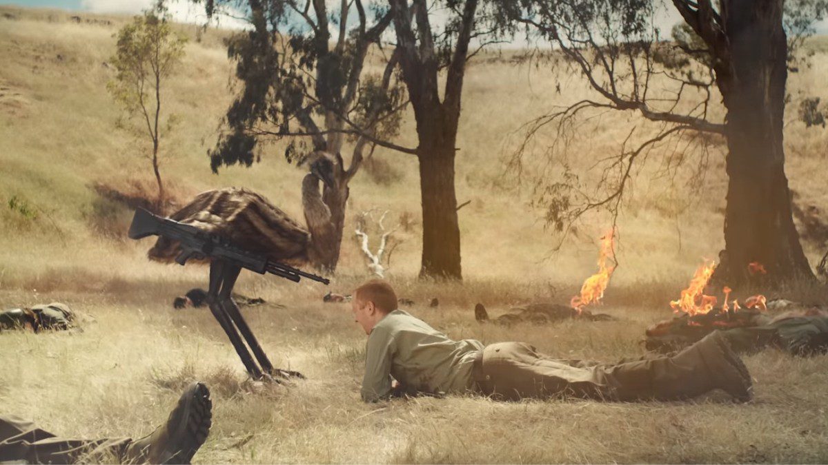 The Emu War movie trailer is the best kind of absurd. An emu aims a gun at a man laying prone on the ground.