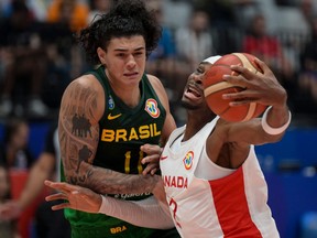 Shai Gilgeous-Alexander du Canada et Gui Santos du Brésil se battent pour le ballon lors du match du groupe L de la Coupe du monde de basket-ball FIBA.