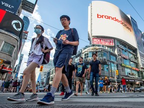 Piétons au centre-ville de Toronto.  La population du Canada a augmenté de 1,1 million de personnes l'année dernière, selon Statistique Canada.